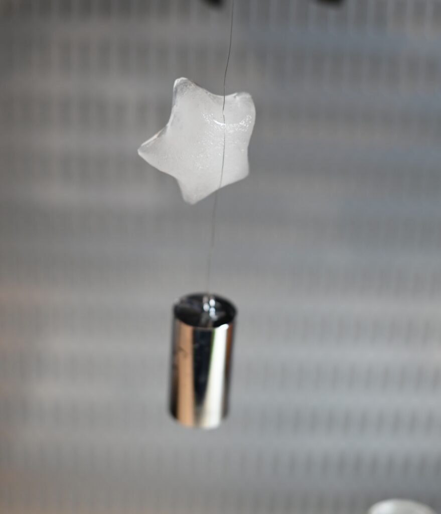 ice cube hanging from a wire for a science experiment about wire cutting through ice