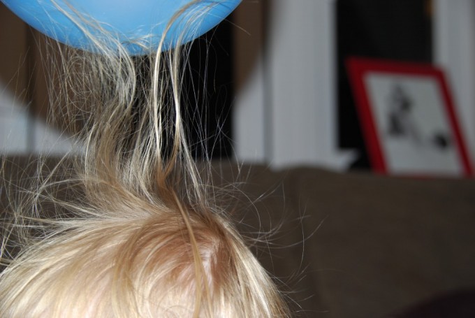 Child's hair stood on end from static electricity on a balloon