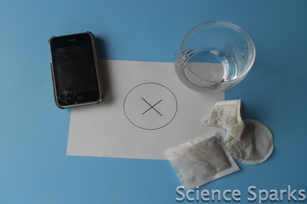 tea bags, a phone, glass mug and paper