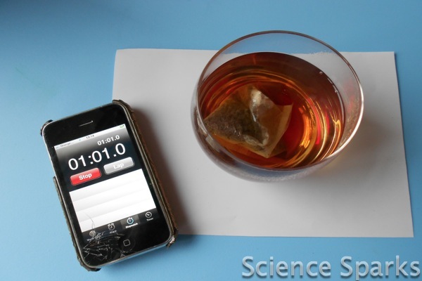 a cup of tea in a clear glass mug and a phone for a diffusion science activity