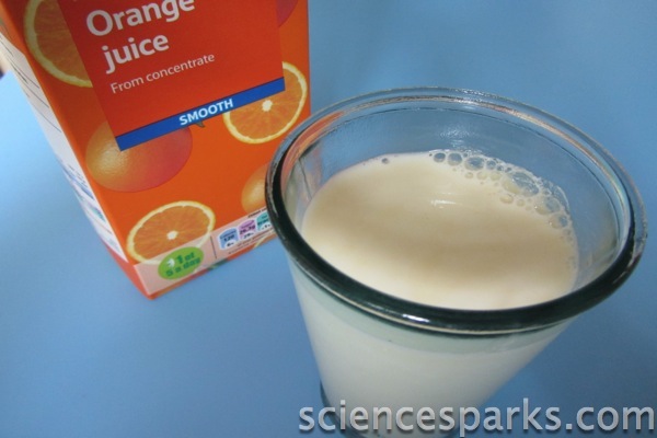 a carton of orange juice next to a glass of milk