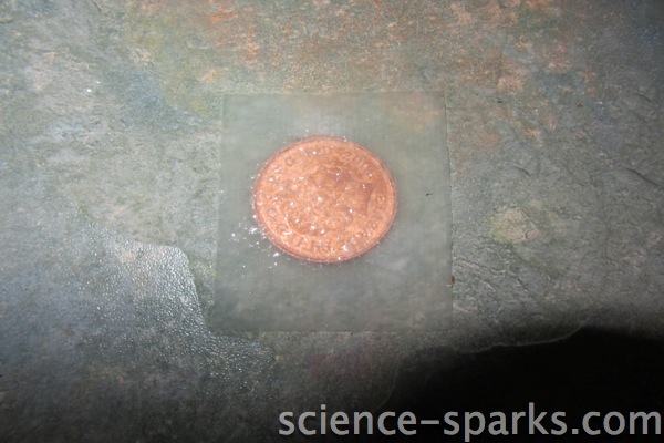 two pence coin covered in water and kitchen towel