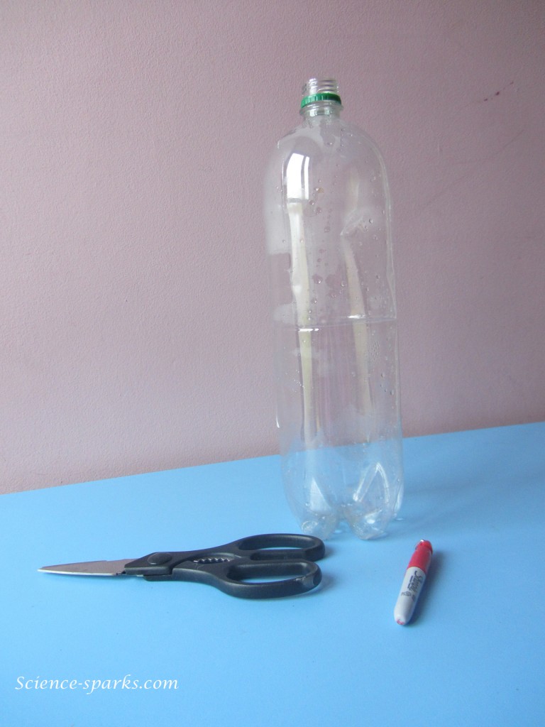 Plastic bottle, scissors and sharpie for making a magnifying glass