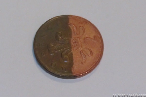 a coin half cleaned with vinegar