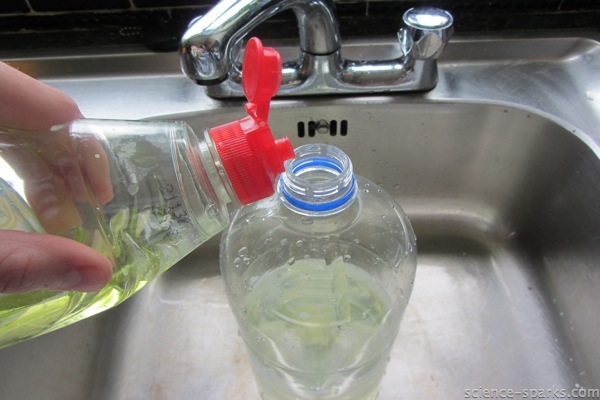 Washing up liquid ( dish soap ) being poured into a plastic bottle for a bubble experiment