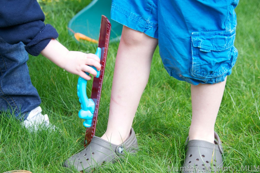 child measuring another child's legs with a ruler