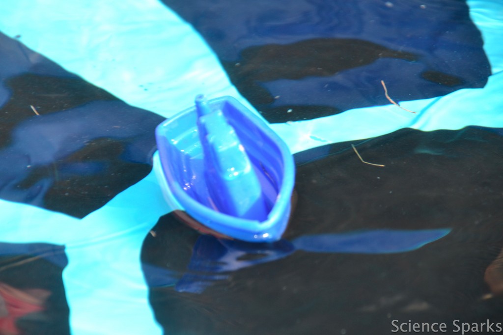 a small plastic boat floating in a paddling pool
