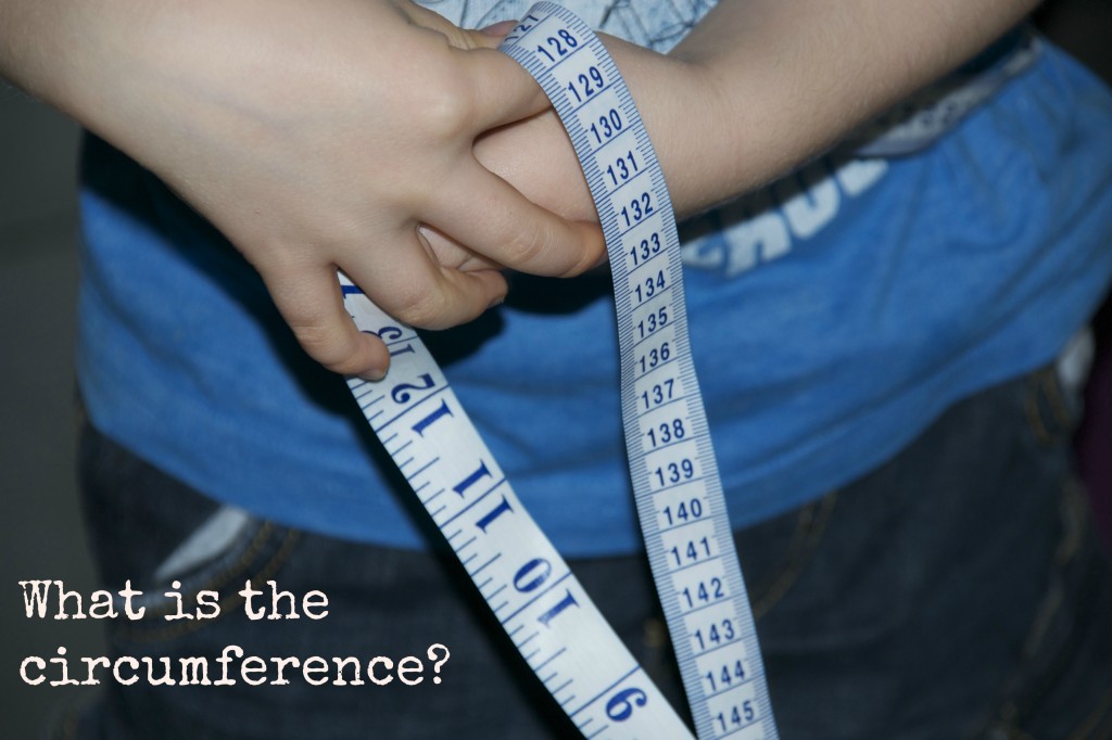 measure pumpkins - image shows a child holding a tape measure