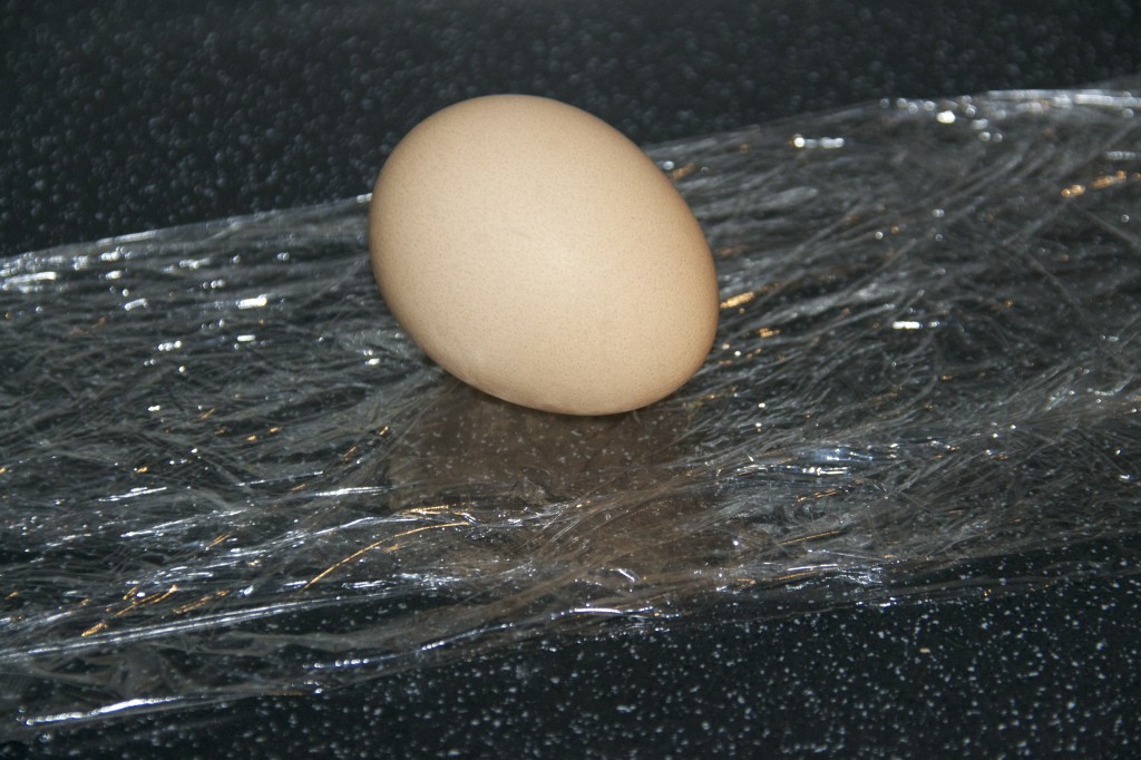 unbreakable egg experiment - image shows an egg sat on a sheet of cling film