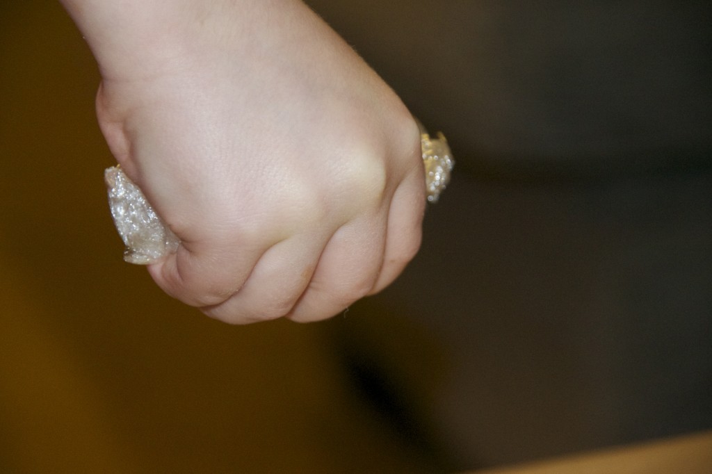 childs hand squeezing an egg covered in cling film