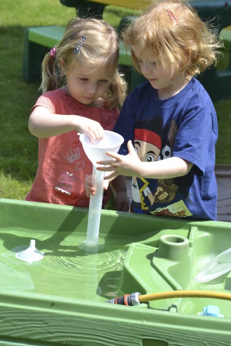 Children playing at a water table - science or kids