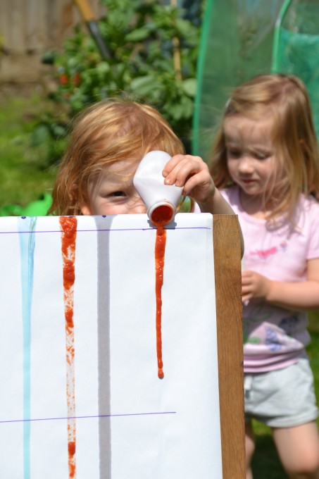 children pouring liquids down a ramp to learn about viscosity