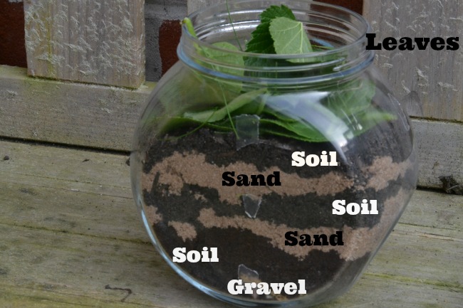 Homemade wormery made with soil, sand and a jar