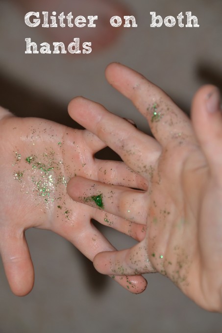 two hands covered in hand cream and glitter for a germ science investigation