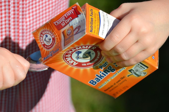Image of a child holding a box of baking soda for a science experiment