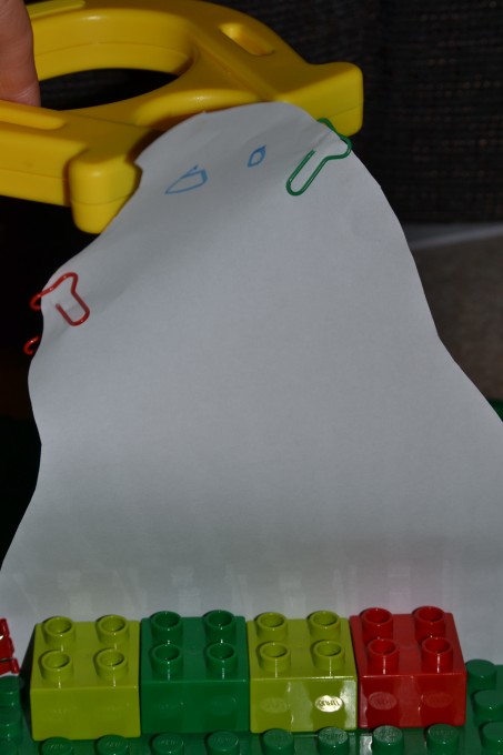 Paper ghost attached to a DUPLO plate with 2 paperclips near the top.