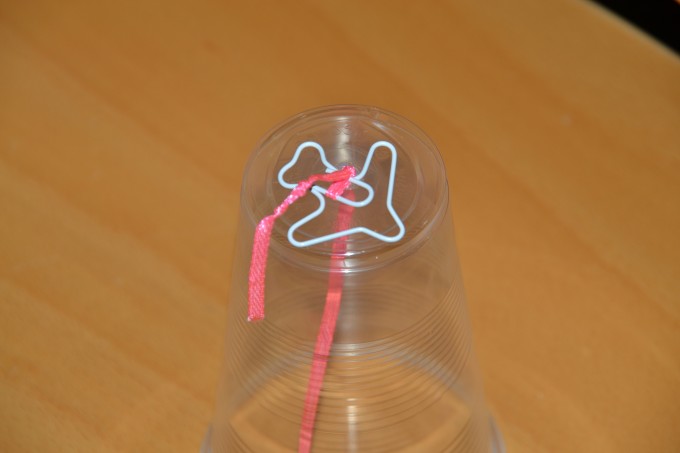 eerie sounds device made with a plastic cup, ribbon and paperclip
