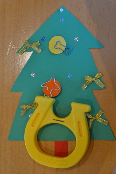 Green cardboard tree with paper baubles with paperclips attached and a magnet for a preschool magnet challenge