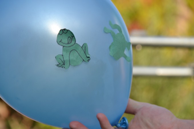 Blue balloon with a green tissue paper frog attached by static electricity