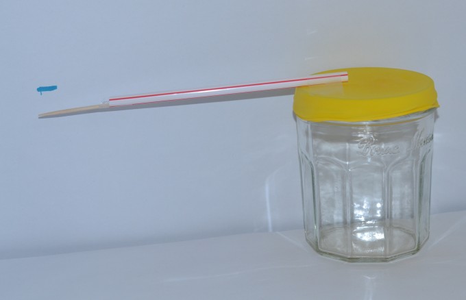 Barometer made from a glass jar, balloon and straw for measuring air pressure.