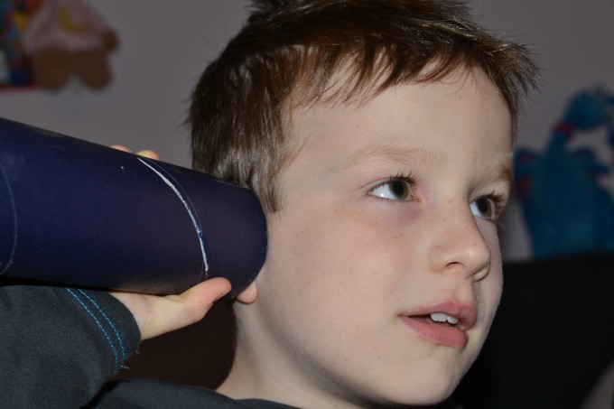 Child with a tube to their ear for a sound experiment