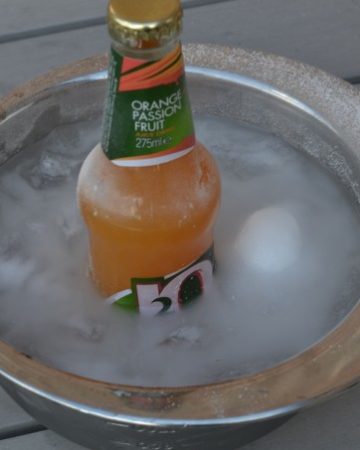 bottle of orange juice in a metal bowl with ice and salt to demonstrate freezing point depression