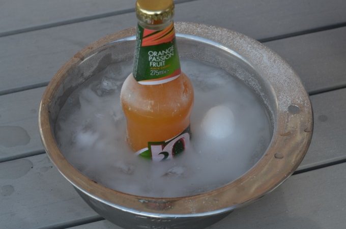 bottle of orange juice in a metal bowl with ice and salt to demonstrate freezing point depression