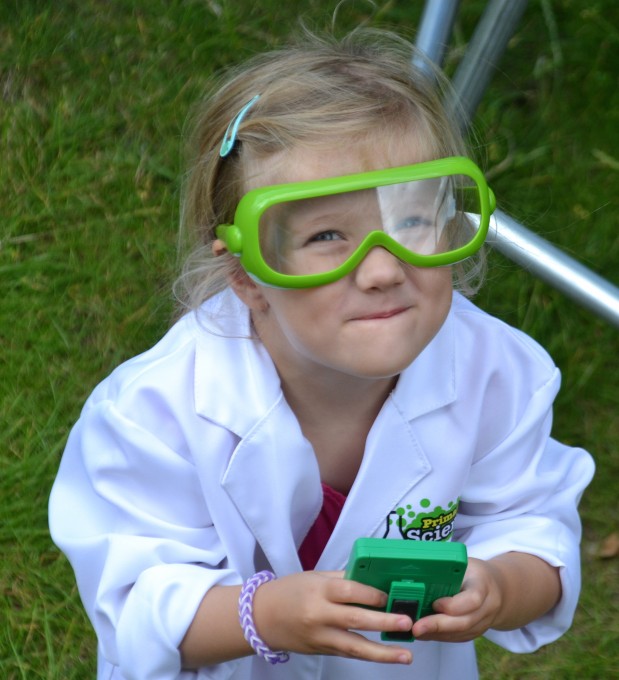 Small girl wearing a lab coat and safety goggles