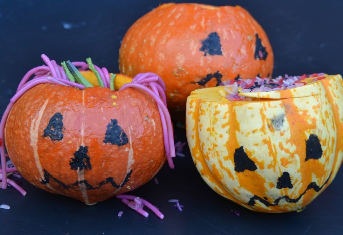 Thee small pumpkins filled with different icky materials. slimy spaghetti, slime and slimy rice