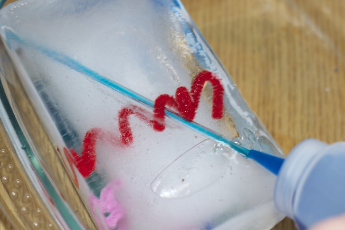 A large block of ice with a gap from a straw that was frozen inside.