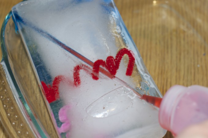 a large block of ice with a pipe cleaner twisted inside
