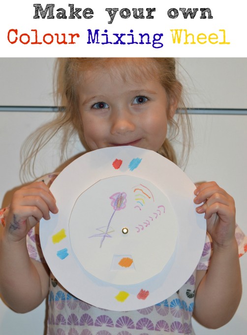 child holding up a colour mixing wheel
