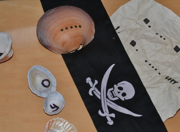 shells wit a code written on the back for a pirate themed science activity