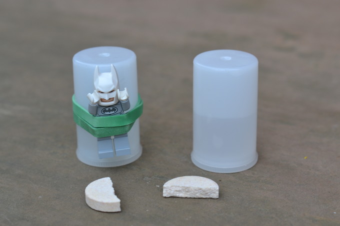 Image of a film canister with a lego man attached by an elastic band.