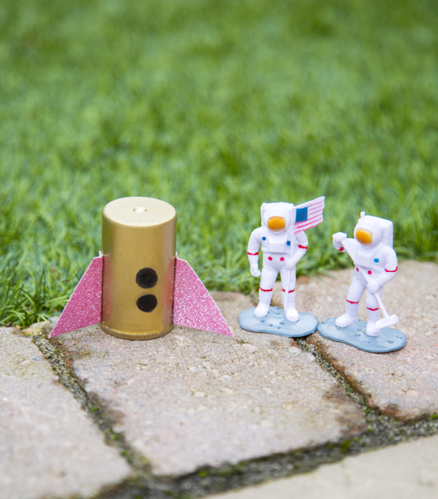 Film Canister rocket with two plastic astronaut figures next to it