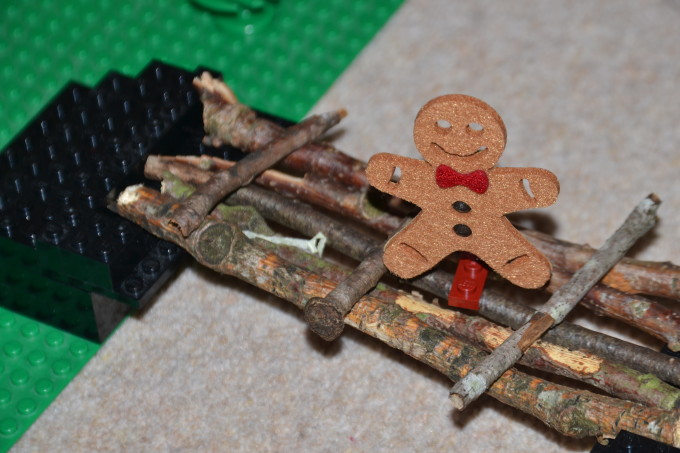 felt gingerbread man on a bridge made from sticks for a science experiment