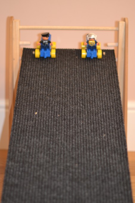 DUPLO cars at the top of a ramp covered in carpet for a friction investigation