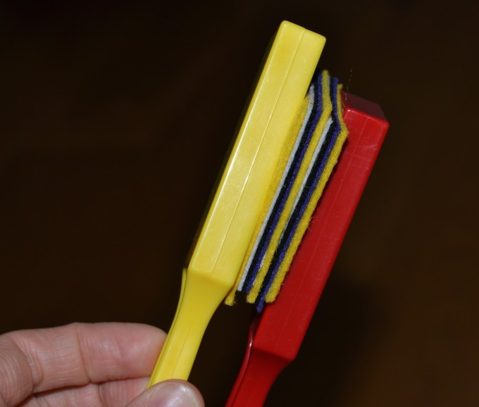 Two magnet wands with about 7 small pieces of felt separating them. The magnets are still attracted to each other.