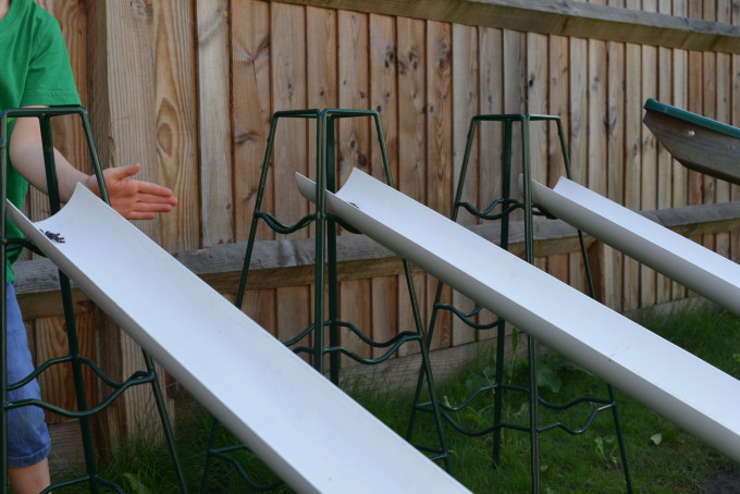three plastic half pipes lined up on a slope ready for a science activity