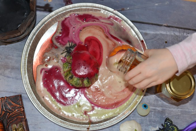 fizzy, colourful baking soda potions in a hollowed out pumpkin for Halloween.