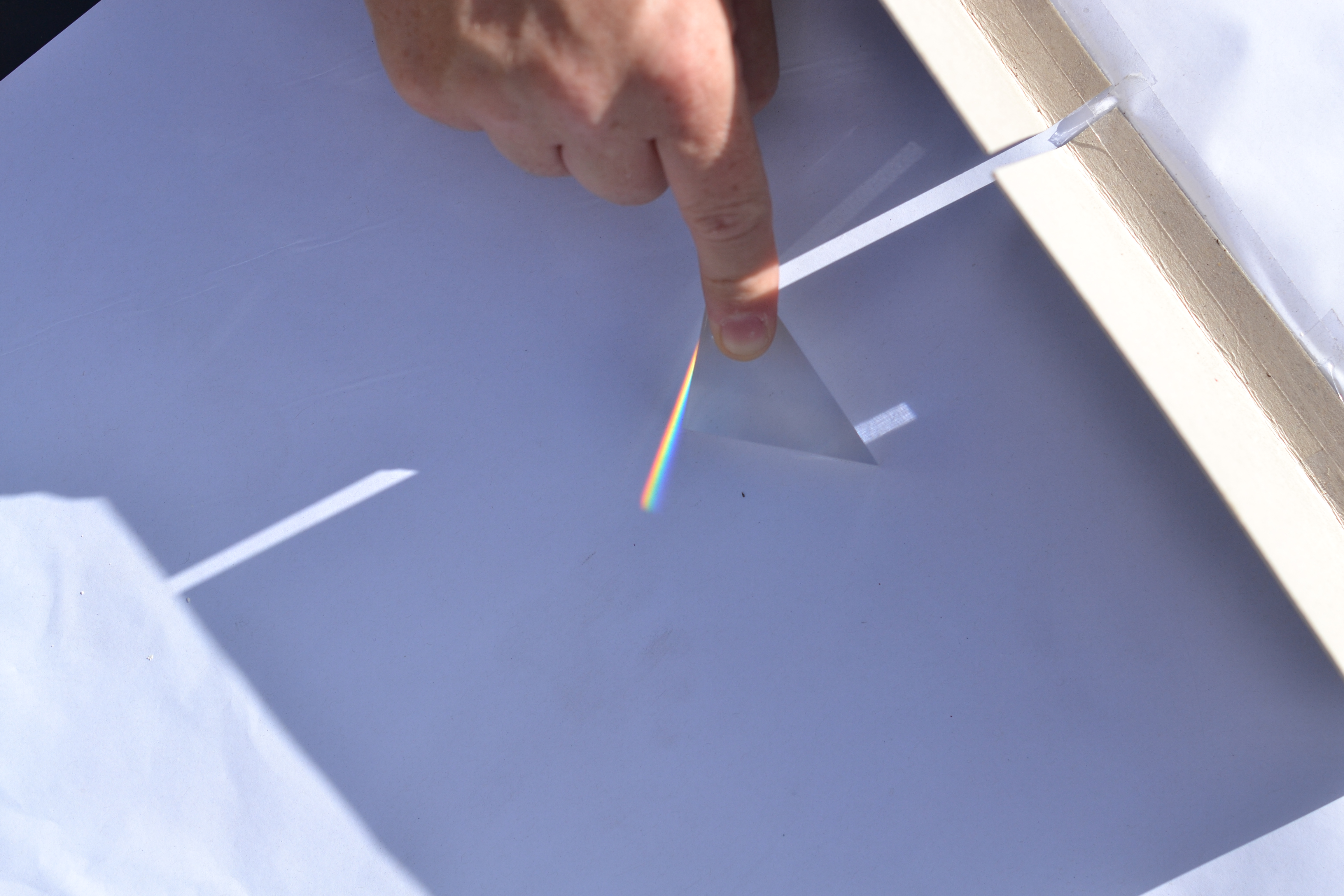 Using a prism to split light into colours to make a rainbow.