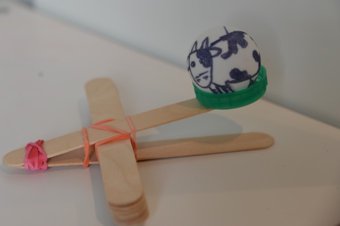 lolly stick catapult with a table tennis ball  decorated like a cow