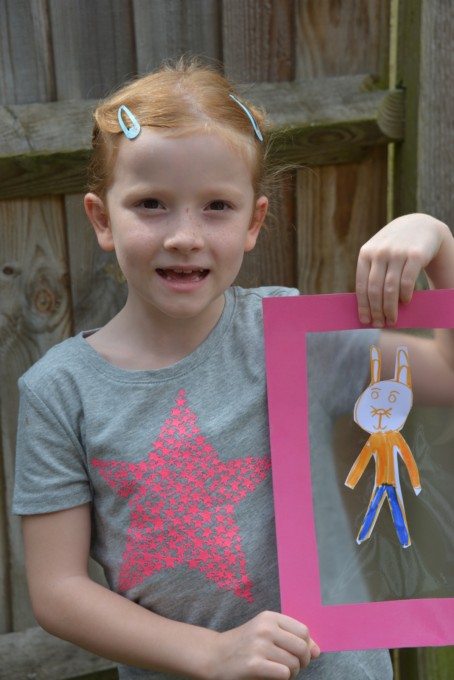 child with a cardboard frame for making shadows
