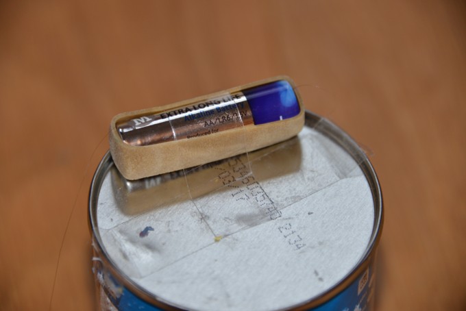 Battery for an art bot - step one - Pringles tube with a battery held in place with an elastic band #artbot