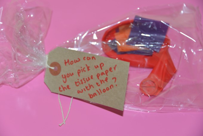 Plastic bag contains a balloon and pieces of tissue paper for a science challenge