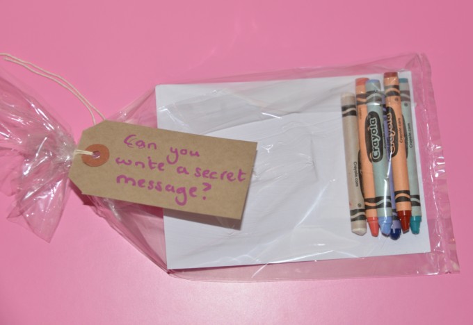 Small plastic bag containing squares of white card and coloured crayons including white for a secret message science challenge