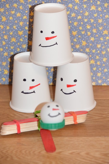 stack of paper cups and a lolly stick catapult for a snowman STEM challenge