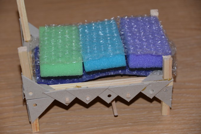 wooden bed frame covered with sponges and bubble wrap for a Princess and the Pea science activity