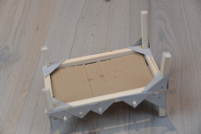 A wooden bed, made from wood and cardboard for a Princess and the Pea experiment.