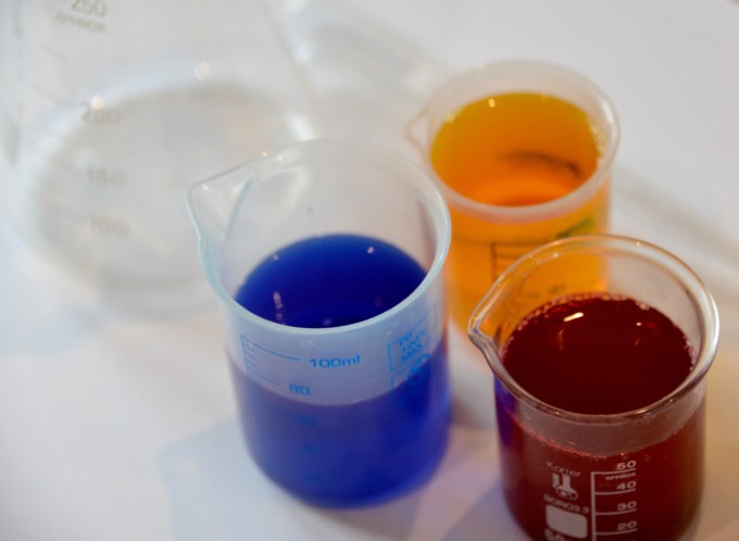 different coloured liquids in small beakers for a colour mixing activity